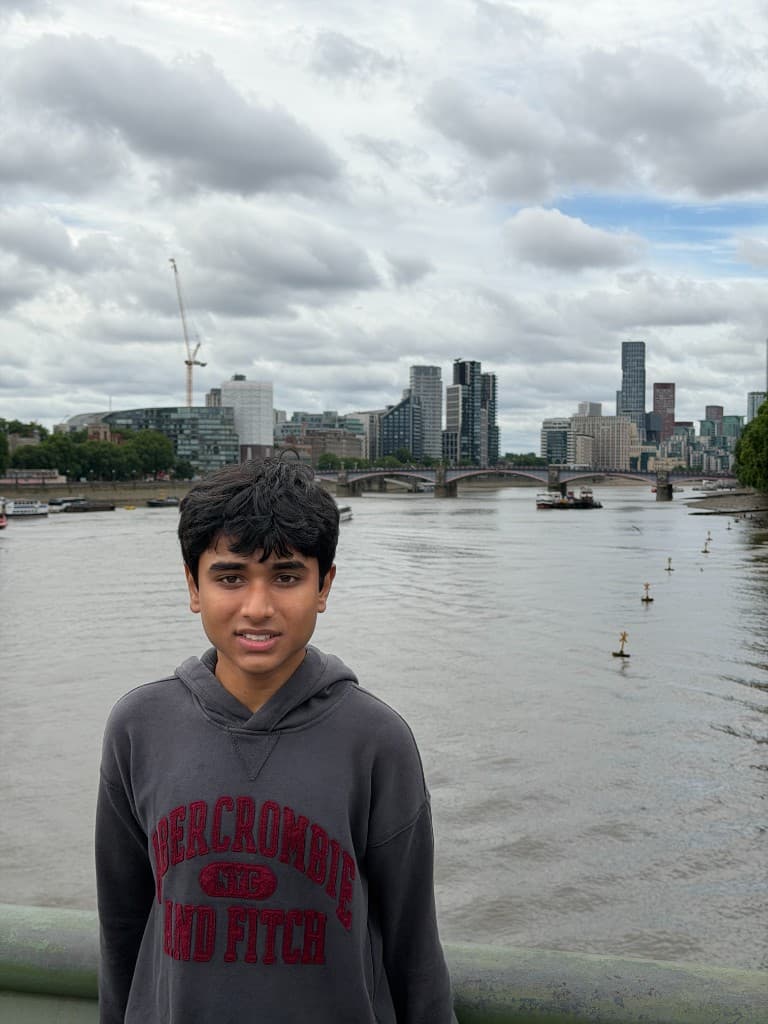 Sudhith Mannuru on a bridge with a city skyline behind him.
